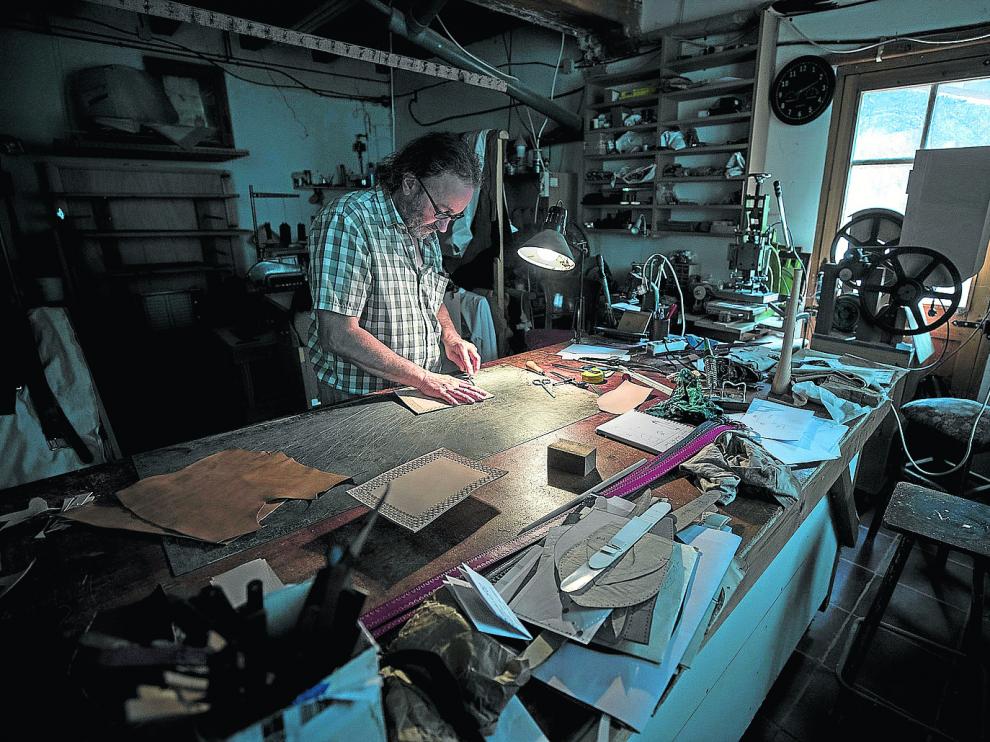 Santiago Lozano, artesano del cuero y la madera, trabaja en su taller de Boltaña.