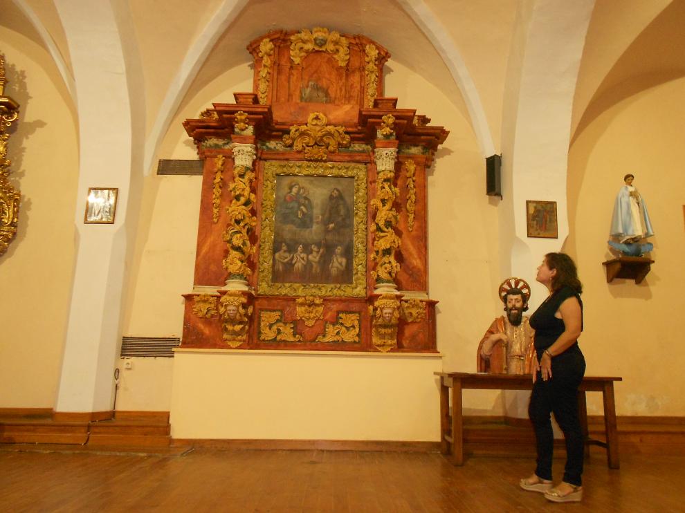 La alcaldesa de Torrellas junto al retablo y el busto restaurado.