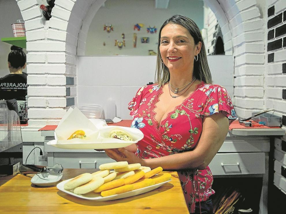 Mayori, con dos platos de arepas, algunas de ellas rellenas, en el bar Molarepa.