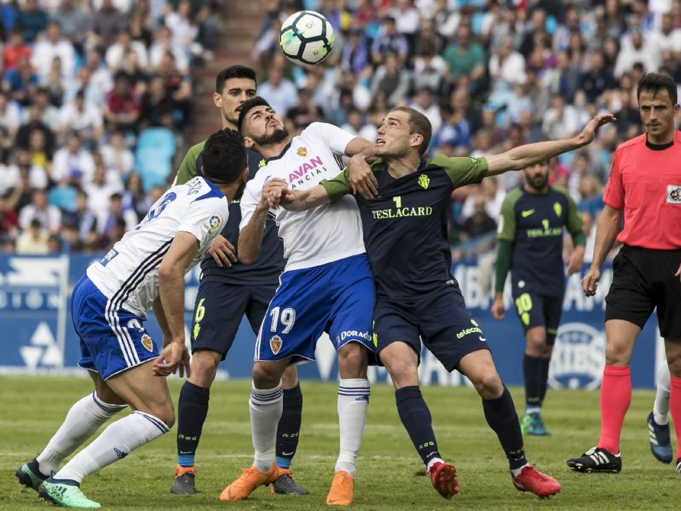 Ais Reig, a la derecha, observa en el área un ataque de Papunashvili y Borja Iglesias, en el último partido que dirigió el alicantino en La Romareda, el año pasado ante el Sporting de Gijón (2-1).