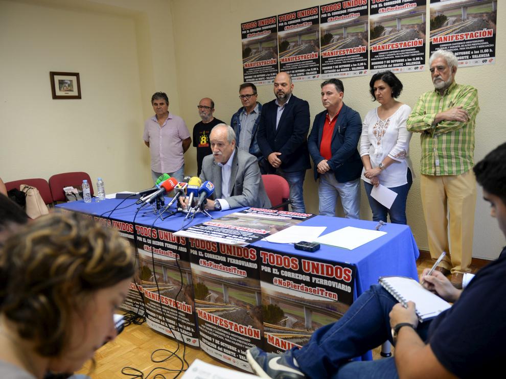 Representantes de las organizaciones convocantes de la protesta, junto al cartel que anuncia la movilización.