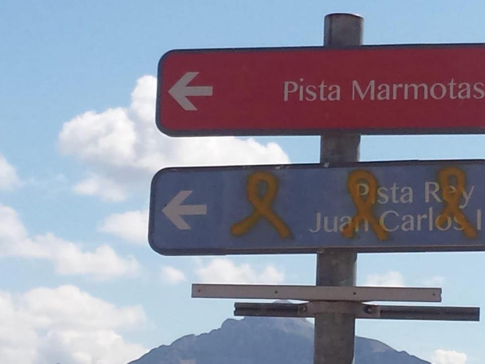Los tres lazos amarillos han sido pintados sobre el cartel indicativo de la pista rey Juan Carlos I