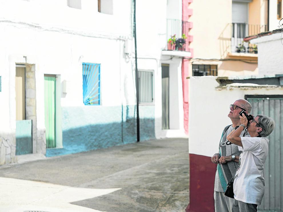 Una pareja de turistas madrileños fotografía la fachada de la parroquia local.