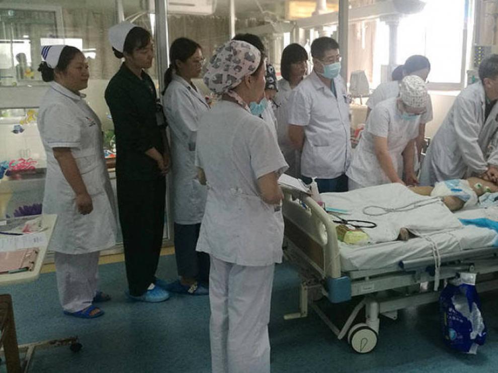 Médicos y enfermeras realizando compresiones torácicas sobre el niño