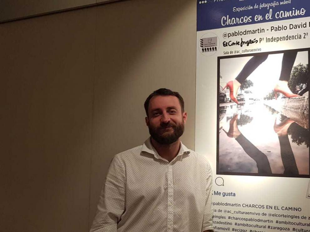 Pablo David, ante el cartel de su exposición 'Charcos en el camino'