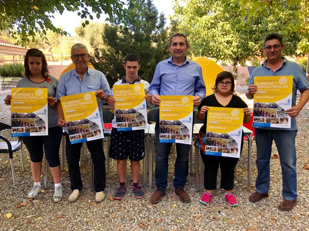 Miembros de la asociación Down Huesca muestran el cartel del evento.
