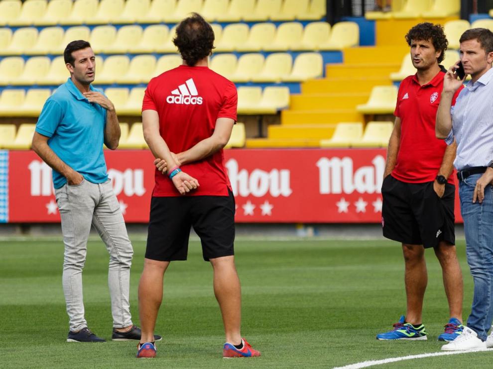 Técnicos y ejecutivos del área deportiva del Real Zaragoza, sobre el césped de la Ciudad Deportiva del Villarreal hace mes y medio, al final de la pretemporada. Jose Mari Barba, secretario técnico (izda. de azul); Imanol Idiakez, el entrenador; Lalo Arantegui, director deportivo (dcha., hablando por teléfono); y, de espaldas, Mario Gibanel, ayudante del técnico.