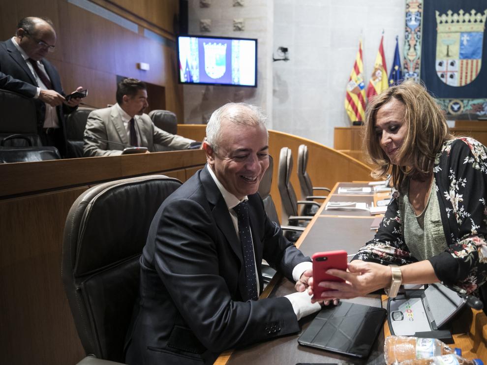 Javier Campoy (PP) conversa con la consejera de Educación Mayte Pérez (PSOE) en un descanso del pleno de las Cortes de este viernes.