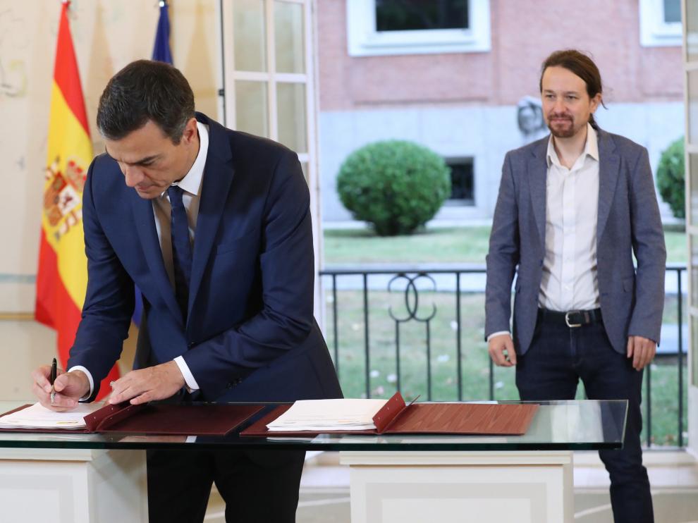 Sánchez e Iglesias firmando el acuerdo presupuestario en Moncloa.