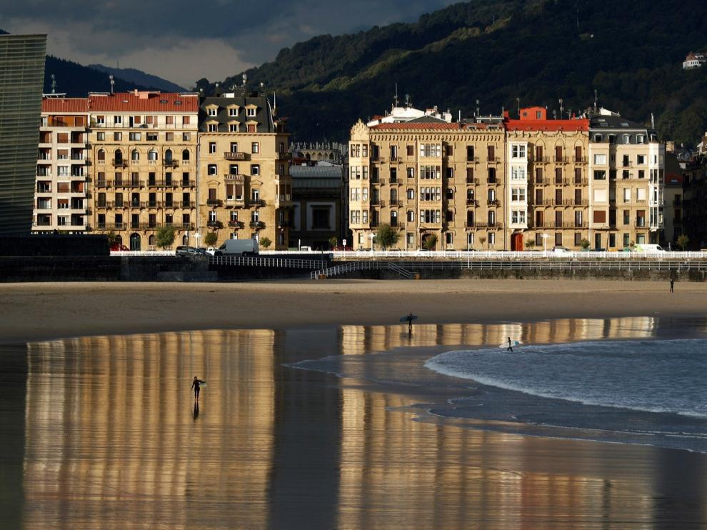 Un surfista camina por la playa de la Zurriola de San Sebastián, donde las temperaturas van a superar los veinte grados en las horas centrales del día. El tiempo previsto para hoy en Euskadi es de cielos poco nubosos o despejados con intervalos de nubes medias y altas, posibles brumas matinales en Álava, temperaturas en ascenso, más acusado el de las mínimas, y viento flojo del sur que subirá en intensidad al final del día en Gipuzkoa y en el extremo oeste de Bizkaia.-