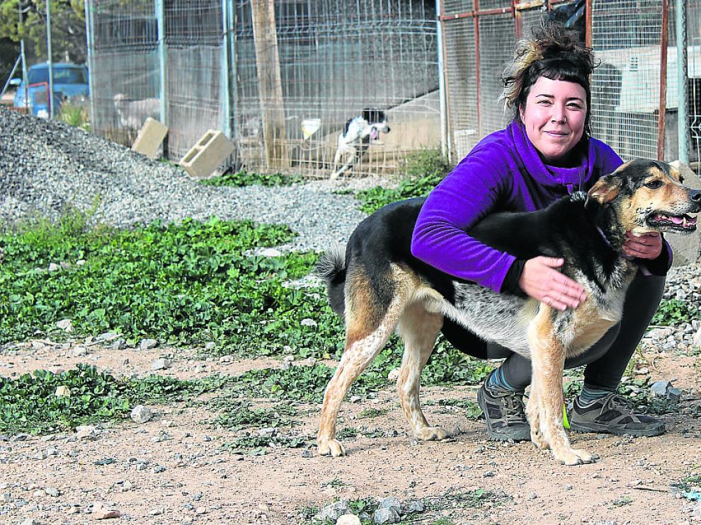 Ana, voluntaria de Amigo Mío, y Bolo, el perro que más tiempo lleva en las precarias instalaciones.
