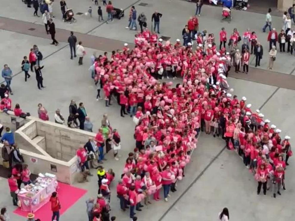 Un gran lazo humano rosa, símbolo de lucha contra el cáncer de mama