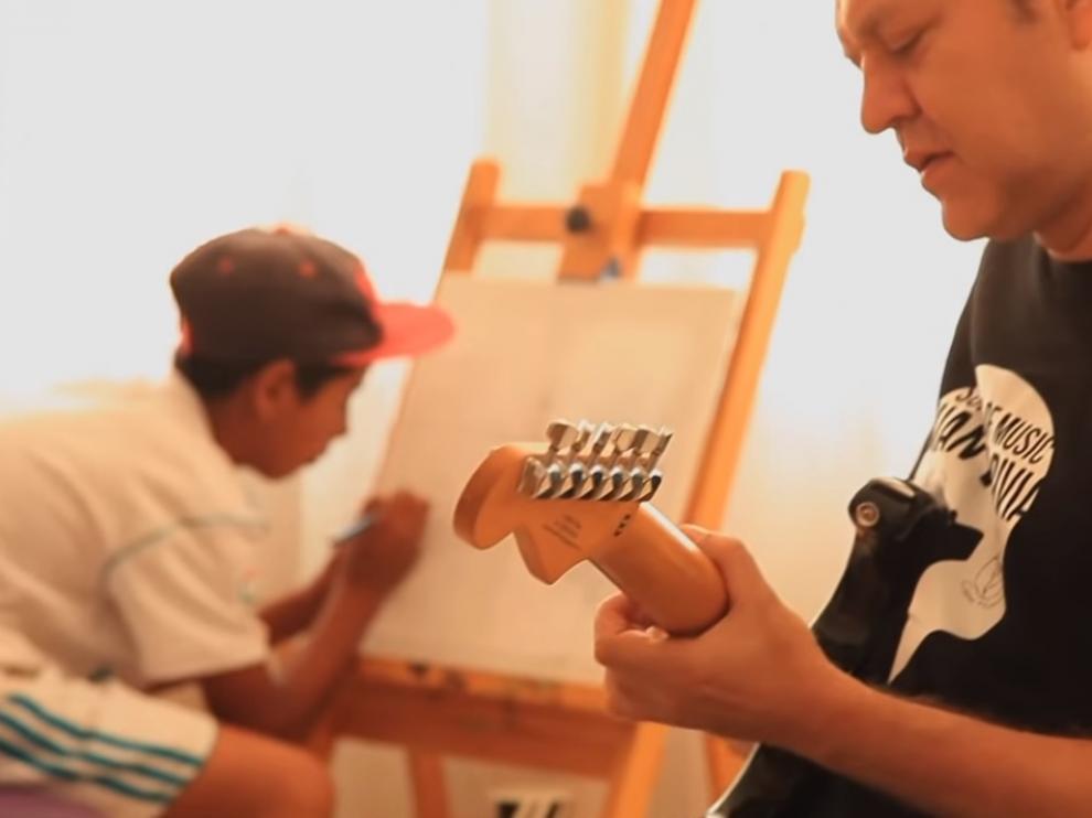 Juan Valdivia toca su guitarra para un niño refugiado