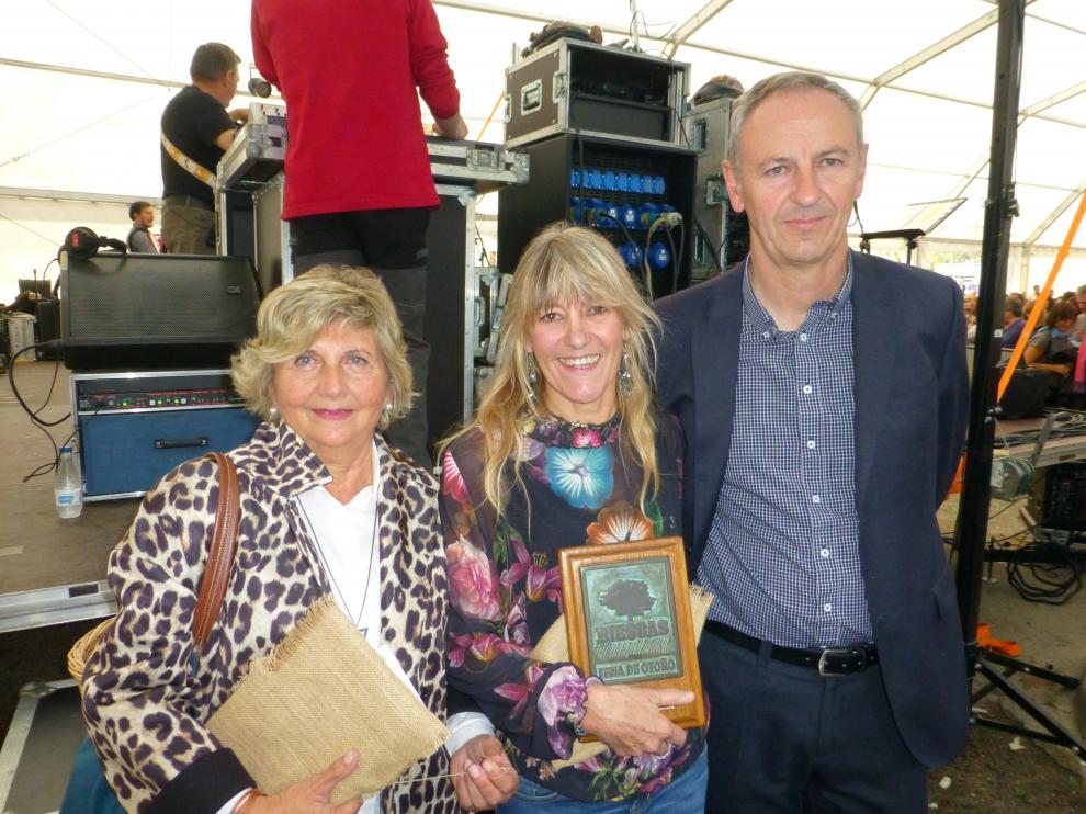 Luis Estaún y Maica Arguas con la directora del CRA Alto Gállego de Biescas. A sus espaldas, el concierto de la Ronda de Boltaña.