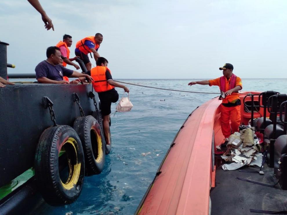 El equipo de Búsqueda y Rescate de Indonesia trabaja evacuando restos del avión en el mar de Java.