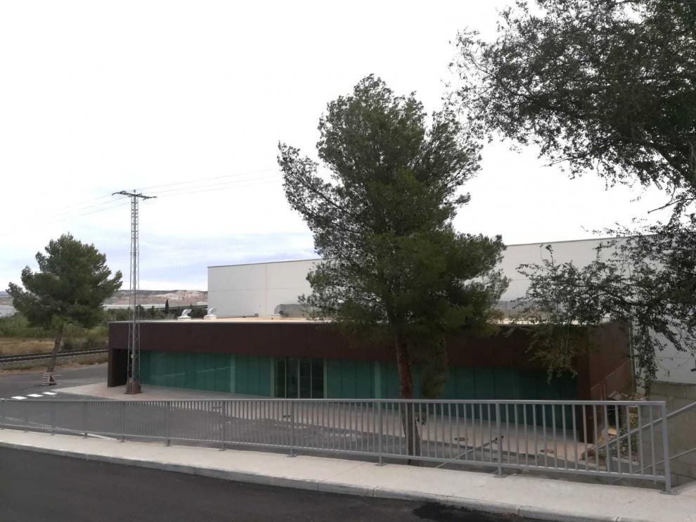 Exterior del nuevo polideportivo de Alagón, con la torre eléctrica delante de la fachada.