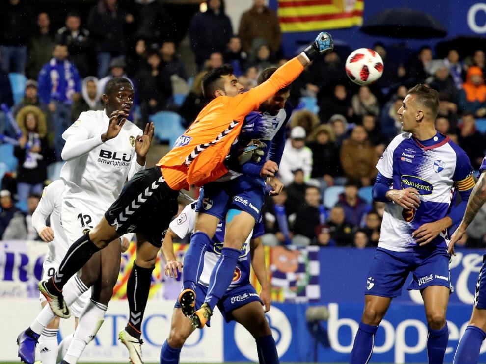 El portero del CD Ebro despeja ante el defensa francés en el partido de este martes contra el Valencia.