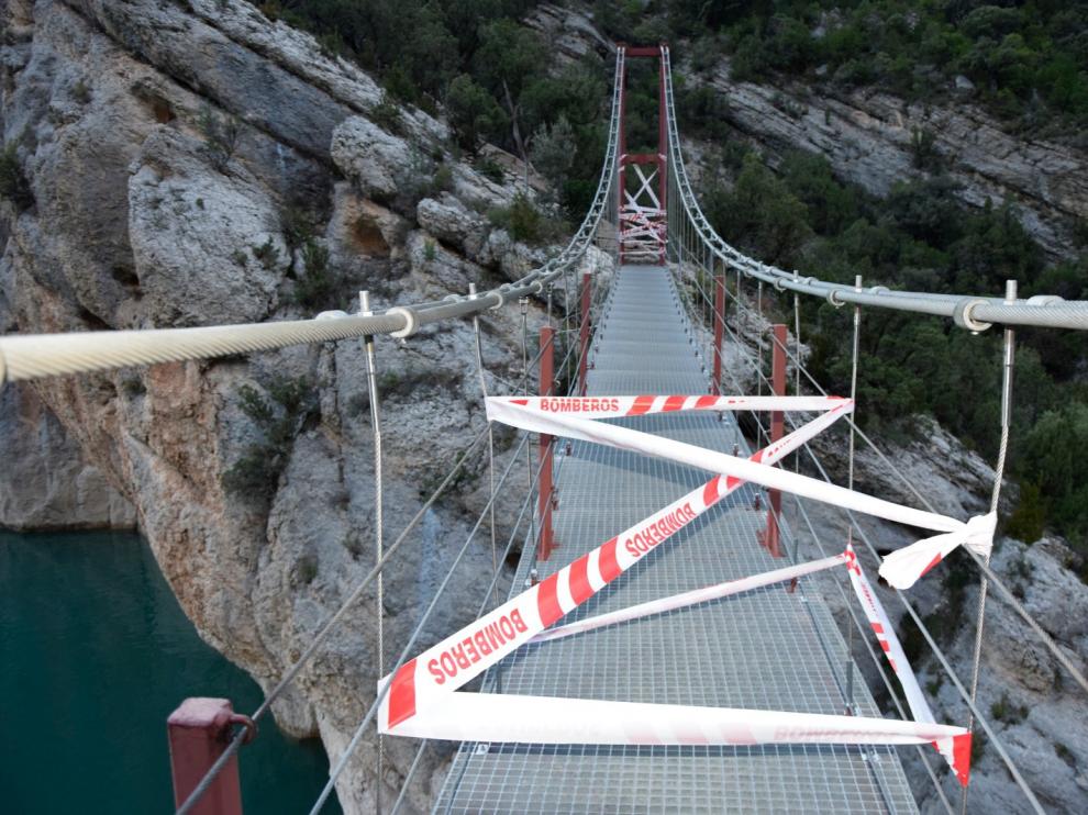 Unas cintas indican que no se puede pasar por el puente que une las dos orillas del congosto.