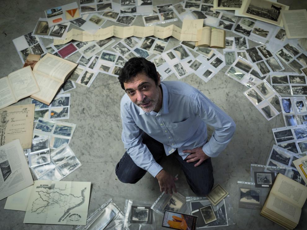 Moncho García, en el estudio Le Plató, rodeado con decenas de fotografías, publicaciones y mapas de su colección sobre Canfranc.