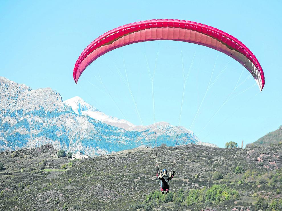 Un parapente biplaza se aproxima a la zona de aterrizaje de La Lleva, en Castejón de Sos.