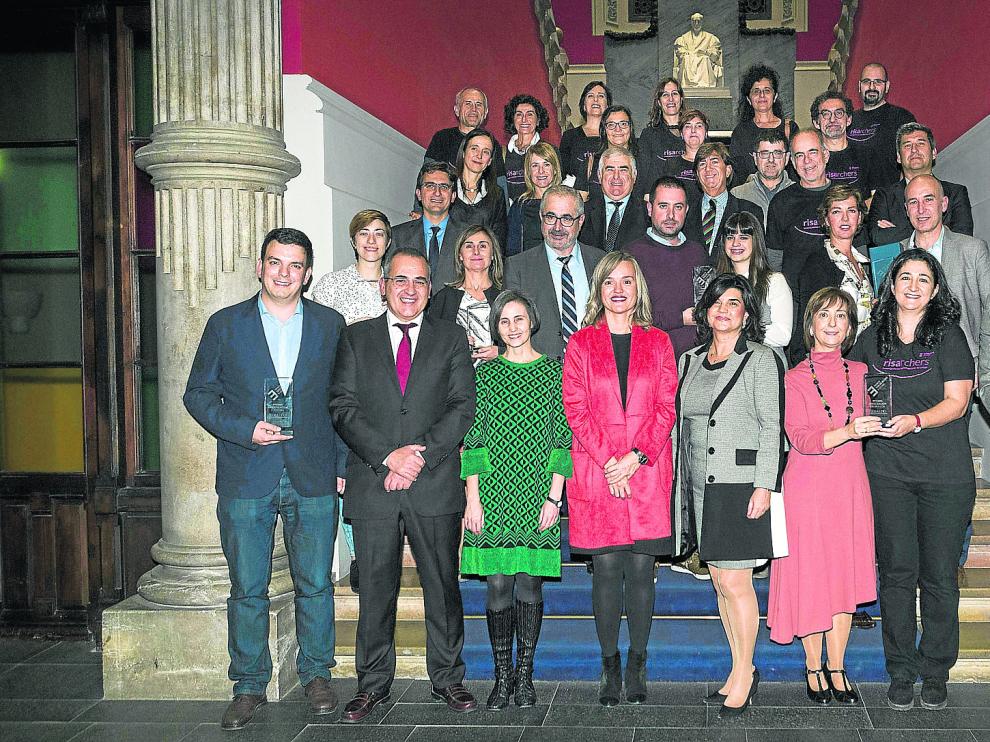 En primera fila, Alberto Jiménez Schuhmacher, Luis Miguel García Vinuesa, Pilar Perla, Pilar Alegría, Paloma de Yarza López-Madrazo, Carmina Puyod, Pilar Lozano y Mikel Iturbe. En segundo fila, Ana Belén Serrano, Mari Carmen Ibáñez, José Andrés Nalda, Marcos Gimeno, Lucía Martínez, Susana Parra y Andrés Llombart. Tercera fila, Íñigo Salinas, y justo detrás, Susana Betrán, Rosa Mauri, Javier Grasa, Jesús Retornano, Luis Rández, Jesús Santamaría y Ángel Fernández. El resto de personas, todas con camisetas negras, son miembros del grupo Risarchers.