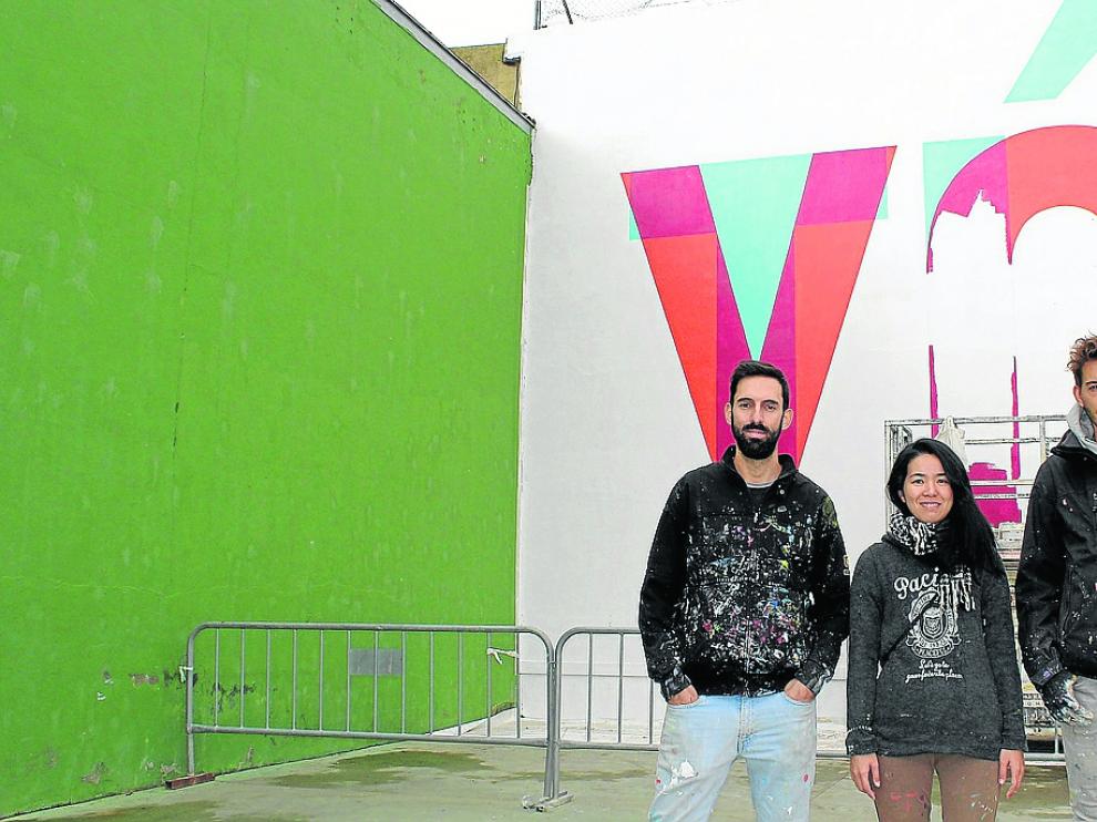 Los artistas de Boa Mistura, ante el mural que han realizado en Grañén.