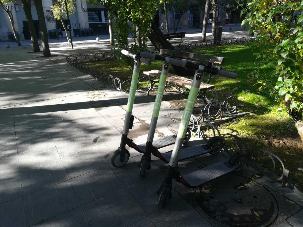 Varios patinetes de Tier, aparcados en la plaza de San Francisco, a escasos metros del campus universitario.