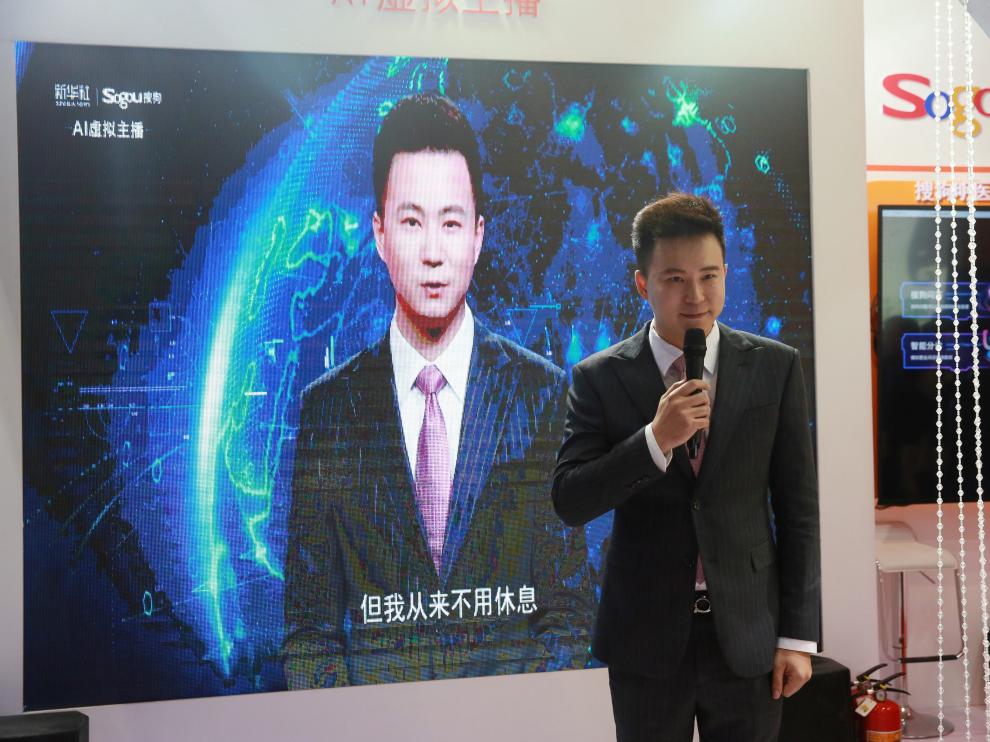 El periodista chino Qiu Hao, ante una pantalla con un presentador virtual basado en su imagen.