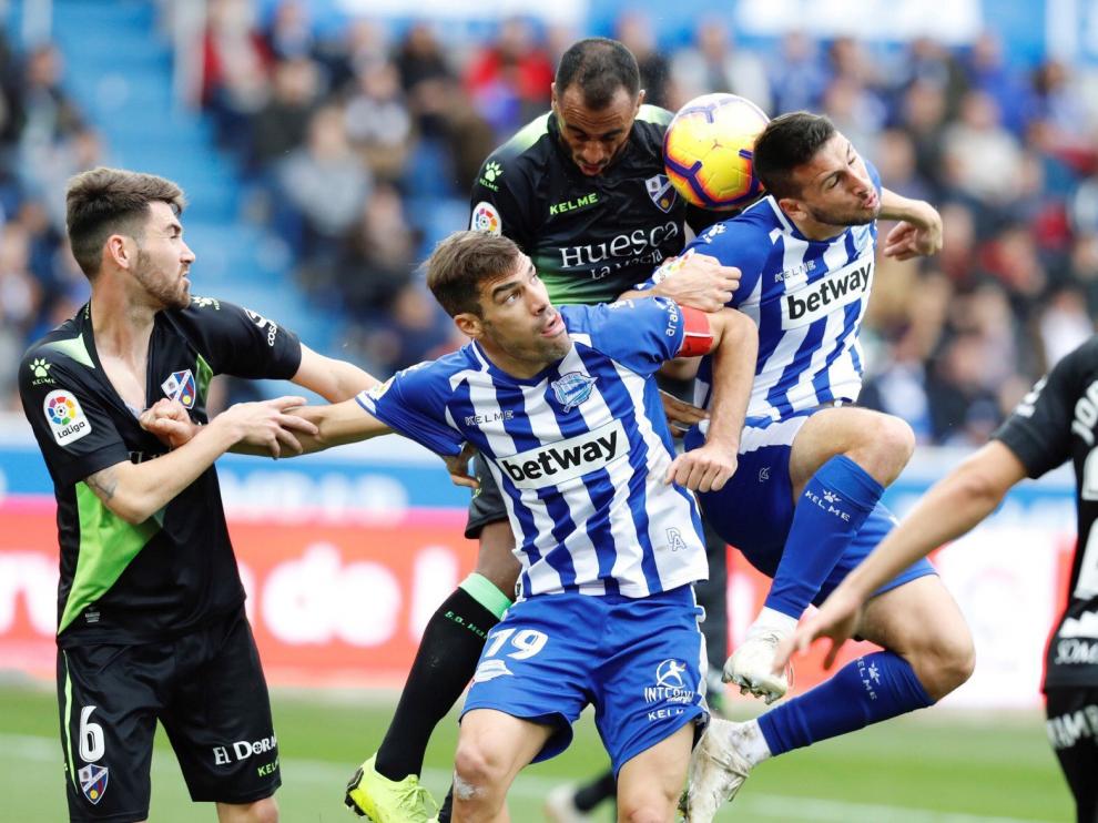 El centrocampista del Huesca Moi Gómez, el defensa del Deportivo Alavés Manu García, el defensa del oscense Carlos Akapo, y el delantero argentino del equipo vasco Jonathan Calleri (i a d) durante el partido correspondiente a la décima segunda jornada de Liga de Primera División disputado hoy en el estadio Mendizorrotza de Vitoria.