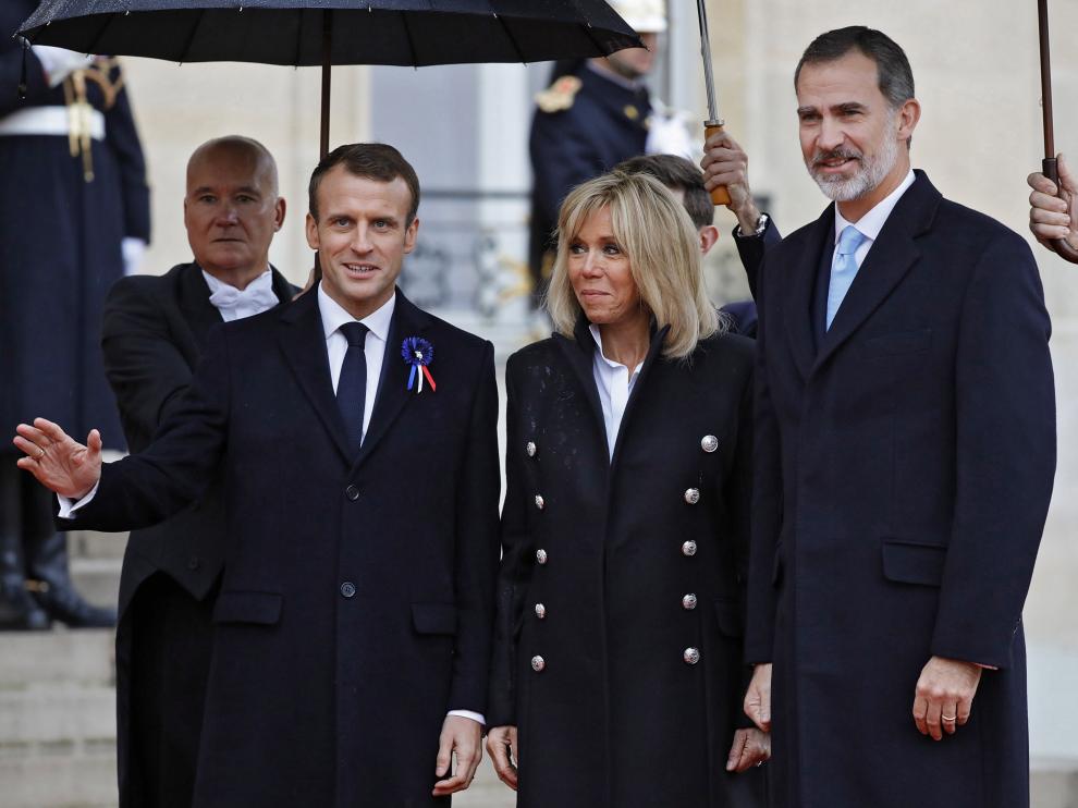 Emmanuel y Brigitte Macron, con el rey Felipe VI, este domingo en París.