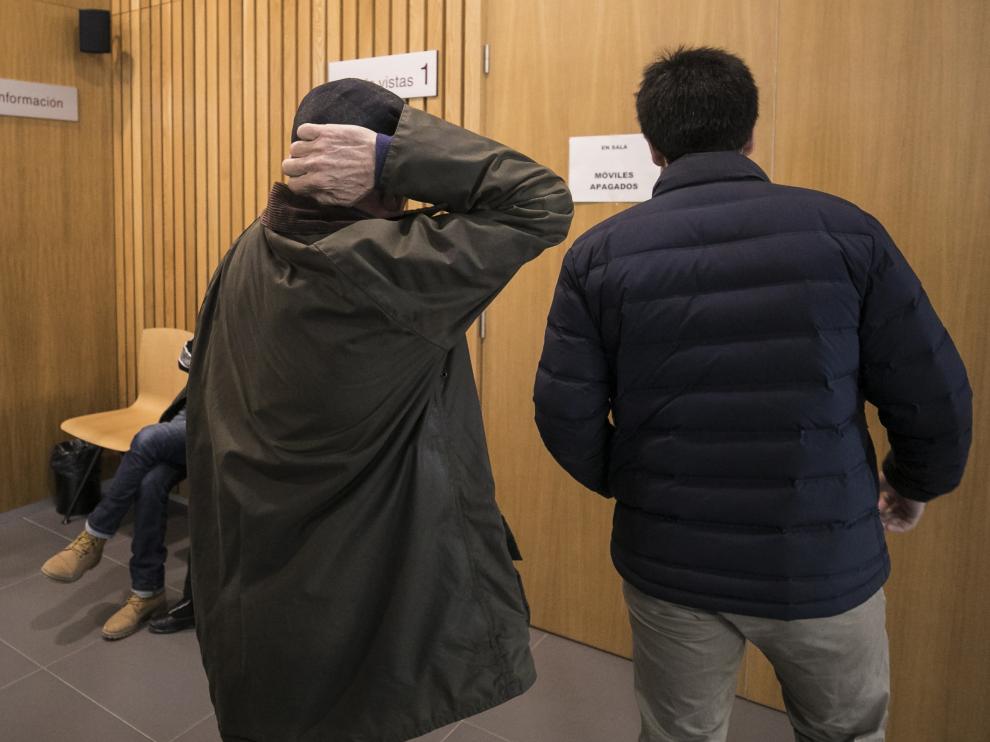 El acusado se cubre la cabeza con las manos antes de entrar en la sala de vistas.