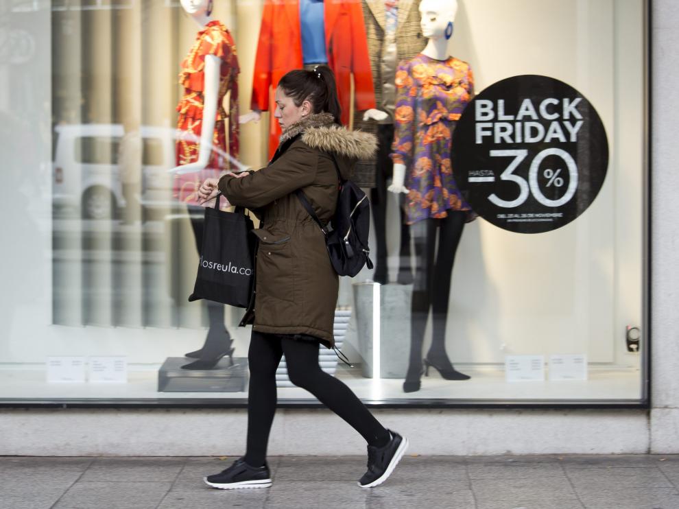 Una mujer pasa frente a un escaparate durante un 'Black Friday'.