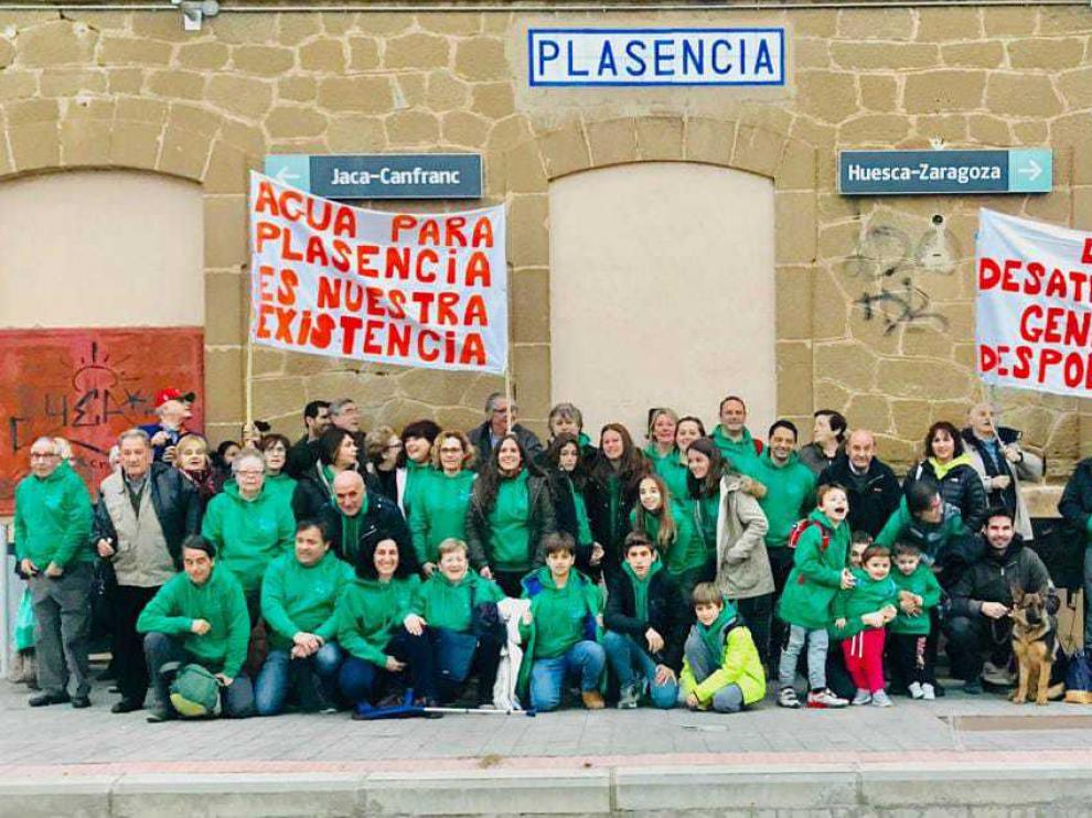 Foto de familia de los vecinos con las pancartas de protesta en el apeadero de Plasencia del Monte