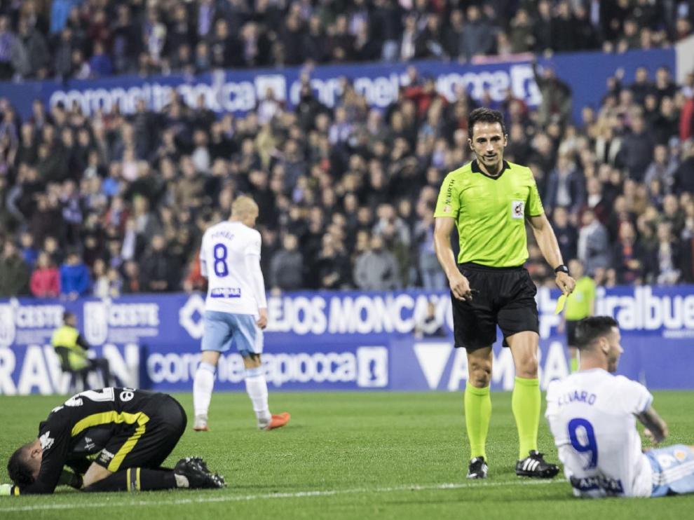 Momento en el que el árbitro Ais Reig va a amonestar a Álvaro Vázquez tras robarle la pelota al portero del Mallorca, Parera, que está en el suelo quejándose para disimular el error que cometió cuando el delantero zaragocista le quitó el balón por detrás en un saque. Por fortuna para él, el reglamento le ampara.