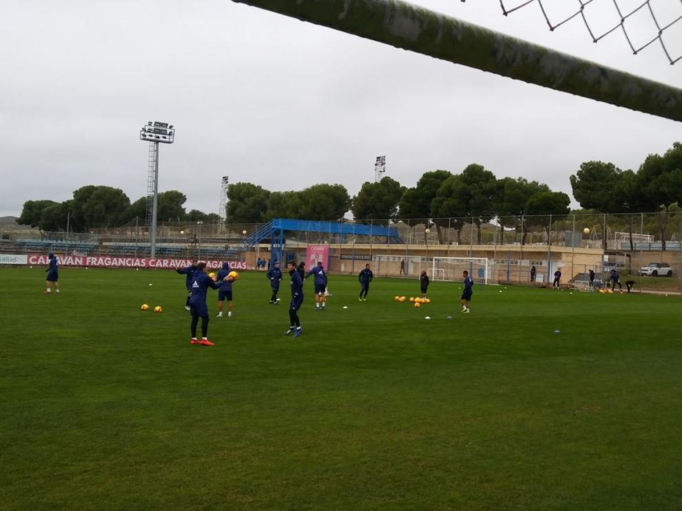 Algunos de los jugadores del Real Zaragoza, bajo la lluvia, en el entrenamiento del mediodía de este domingo tras jugar contra el Mallorca.