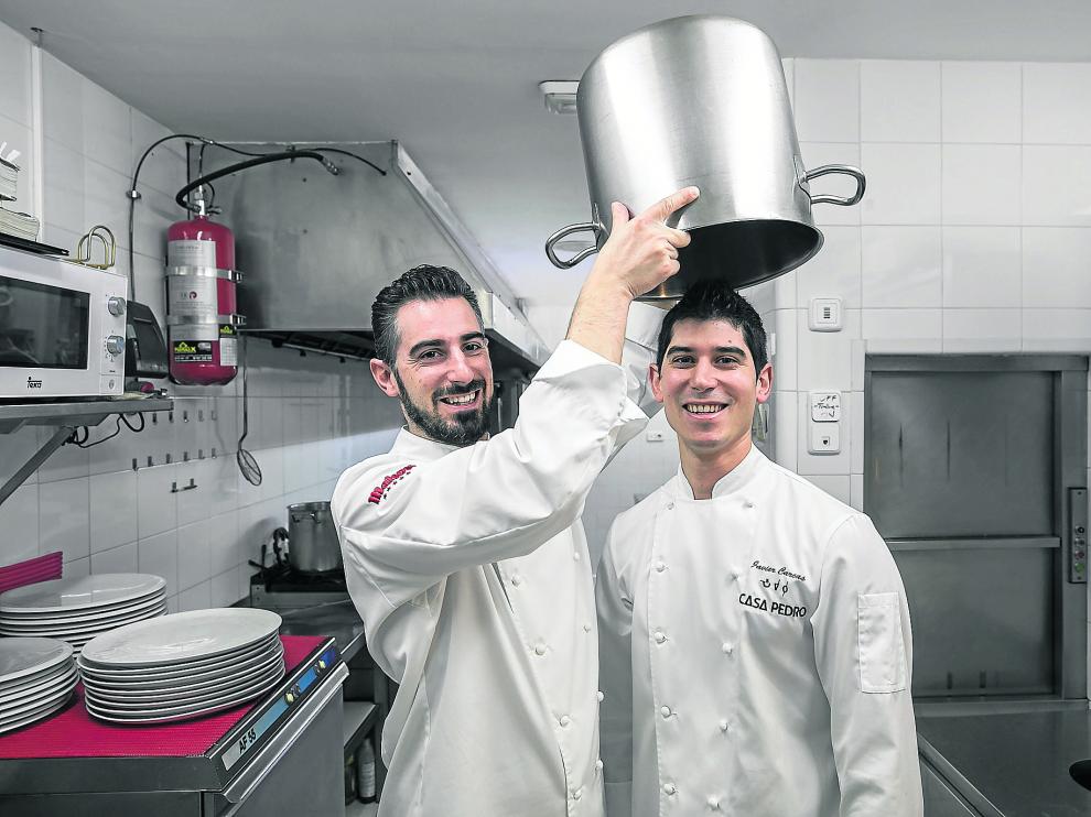 Luis Carcas izqda. bromea con su hermano Javier en las cocinas de Casa Pedro, su restaurante en Zaragoza.