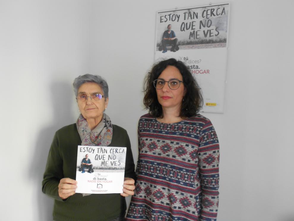 Raquel Mayayo (izq.) y Gema López (der.) de Cáritas Tarazona posan con el tríptico de la campaña.