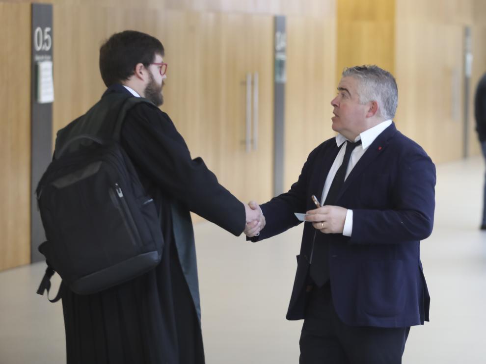 El abogado Javier Vilarrubí, a la derecha, estrecha la mano de otro de los letrados del caso tras cerrar un acuerdo entre todas las partes