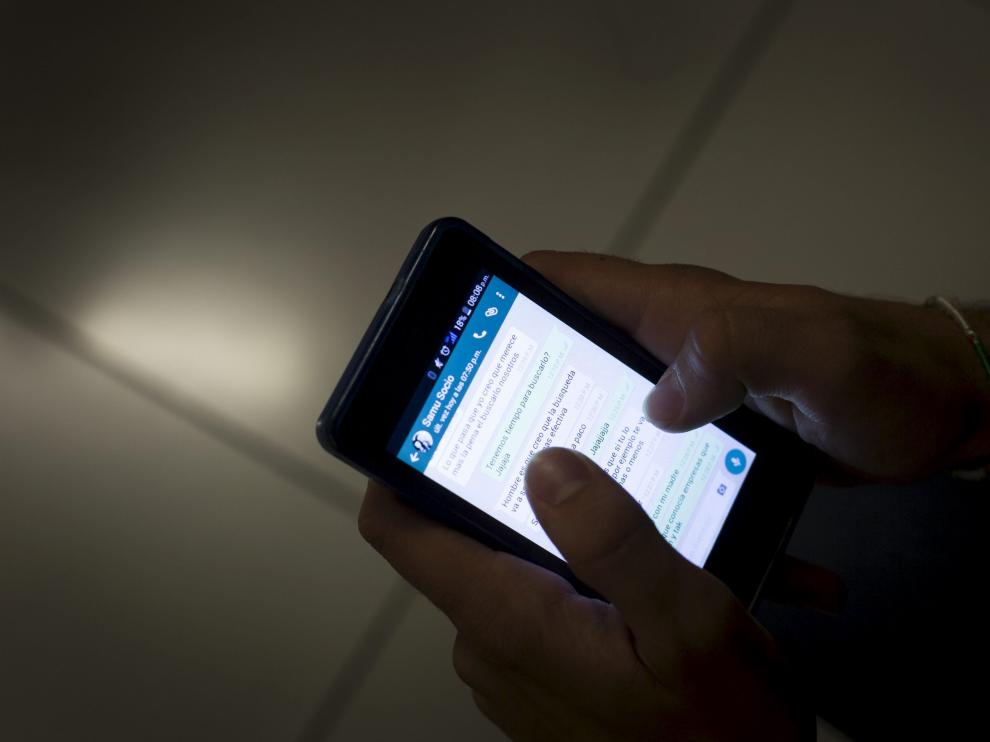 Un joven escribe wasaps con su smartphone