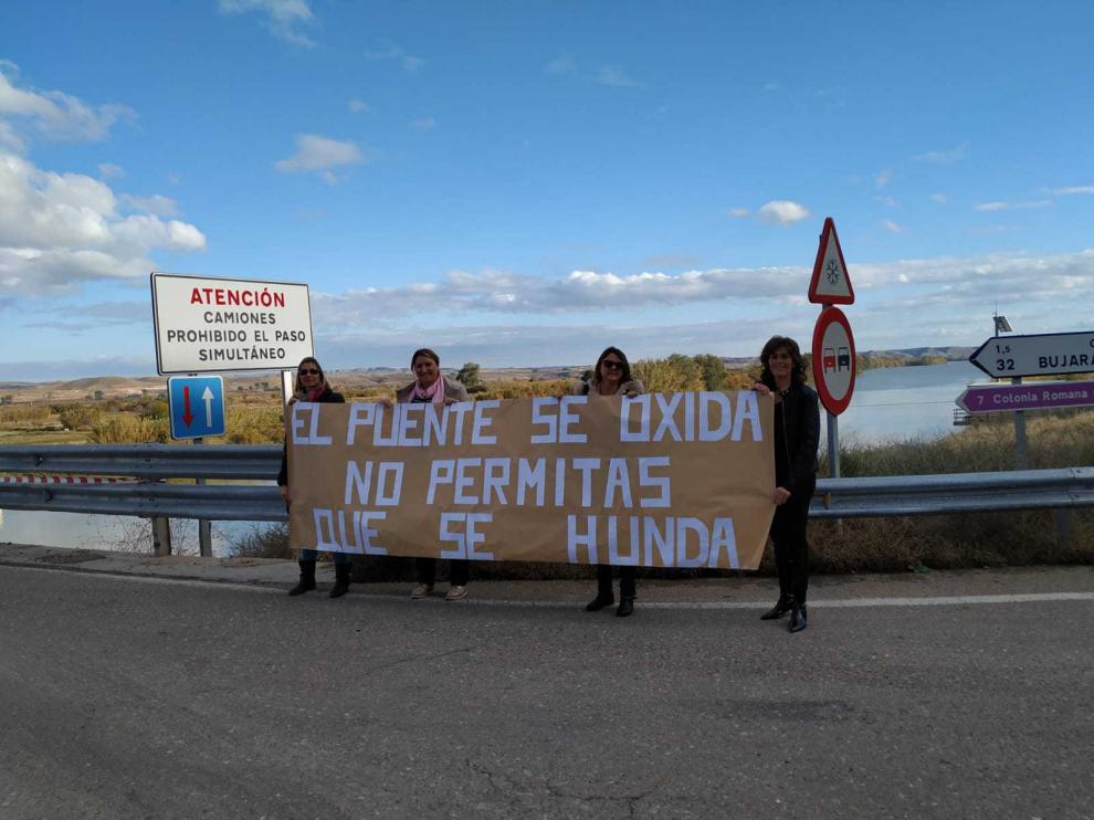Reyes, Mari Carmen, María José y Tere, madres de alumnos, con una pancarta en el puente.
