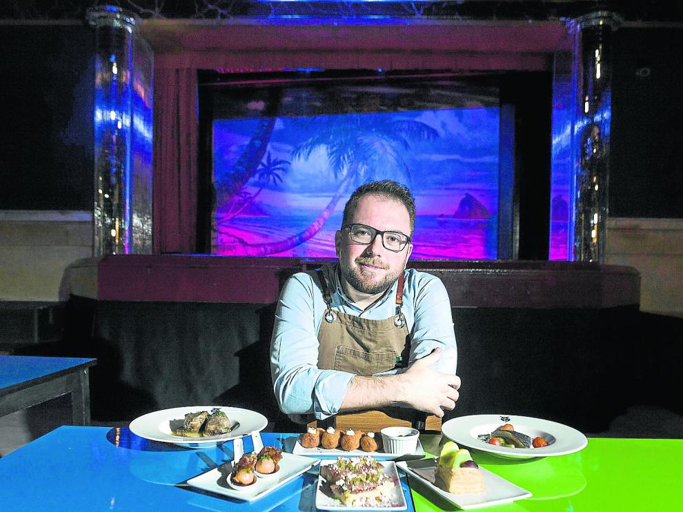Alberto Brosed, apoyado en las singulares mesas del Café El Plata y su escenario al fonda, posa con sus recetas.