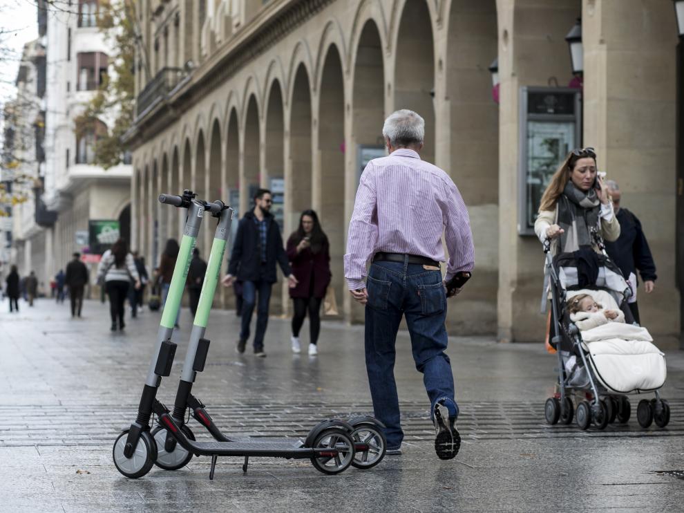 Dos patinetes aparcados en mitad del paseo de la Independencia.