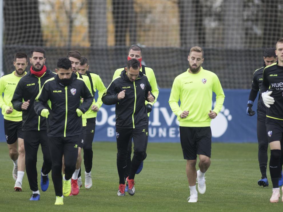 Los jugadores de la SD Huesca, corren durante el entrenamiento del jueves.