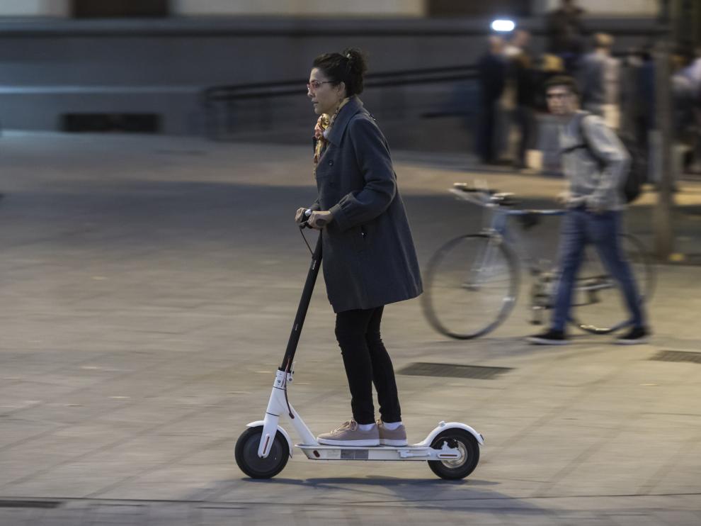 Un usuario de un patinete eléctrico, circulando por una acera.