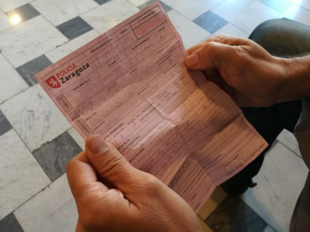 El taxista muestra el boletín de denuncia que le va a costar 60 euros.