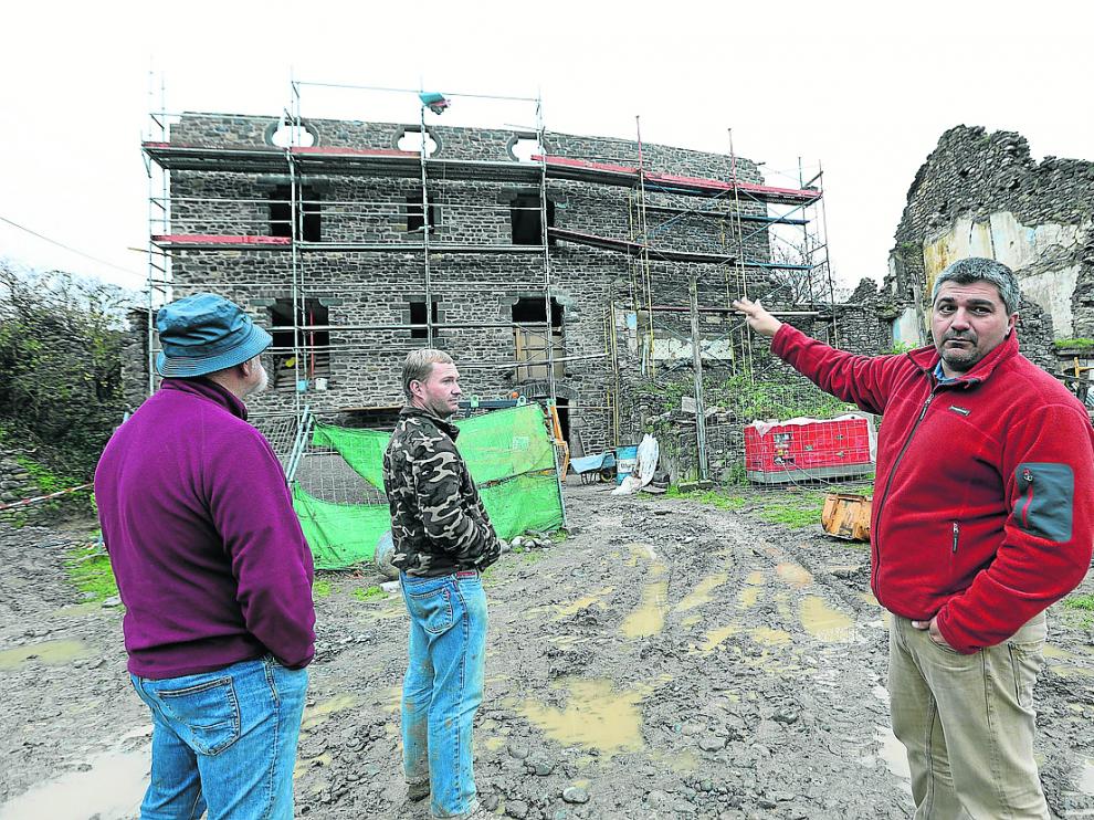 Óscar Espinosa, con Javier y Jesús Garcés, delante de la casa que construye el primero.