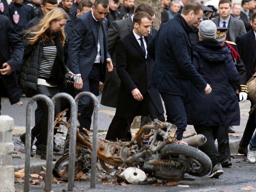 Macron pasa por delante de una motocicleta calcinada en los disturbios