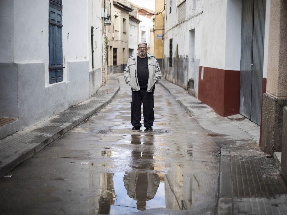El cocinero y escritor local Jesús Aznar (con su reflejo en el agua) posa en una estrecha calle de Lumpiaque.