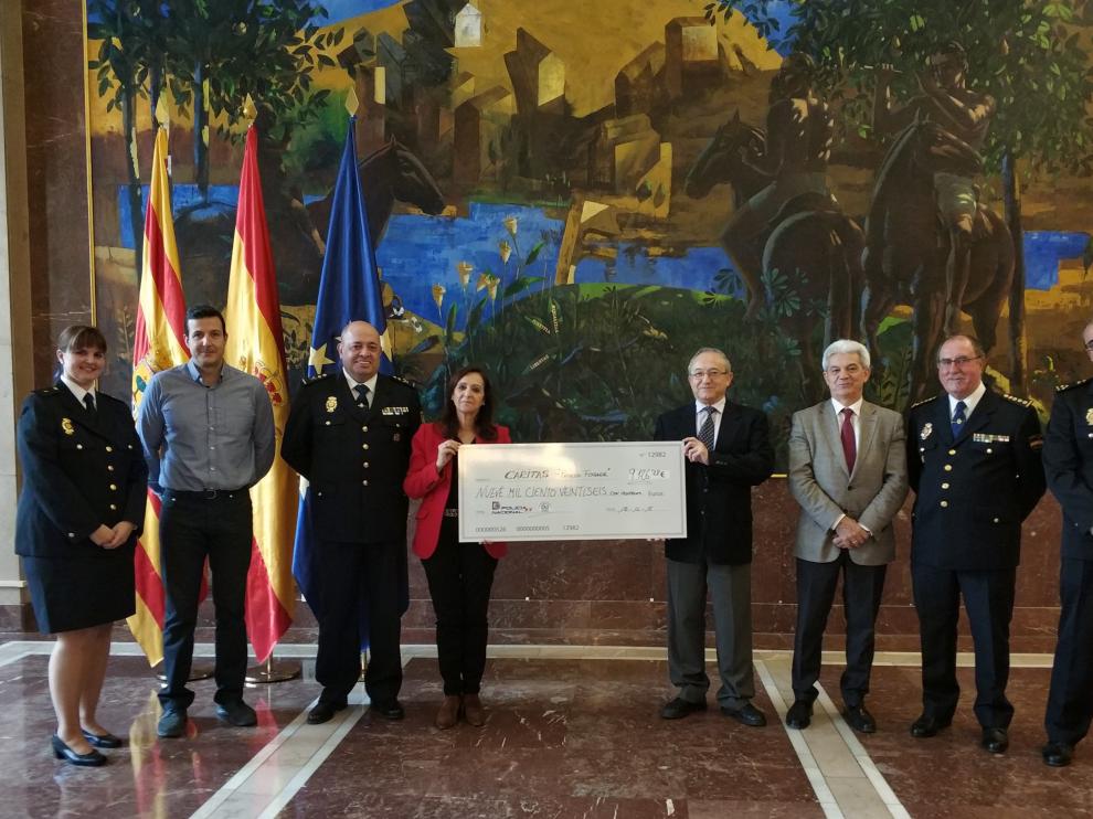 La delegada del Gobierno en Aragón, Carmen Sánchez, entregó un cheque a Carlos Gómez Bahillo, director de Cáritas Aragón, en presencia del Jefe Superior de Policía de Aragón, Juan Carlos Hernández; y del Comisario Provincial, Jesús Navarro, entre otros.
