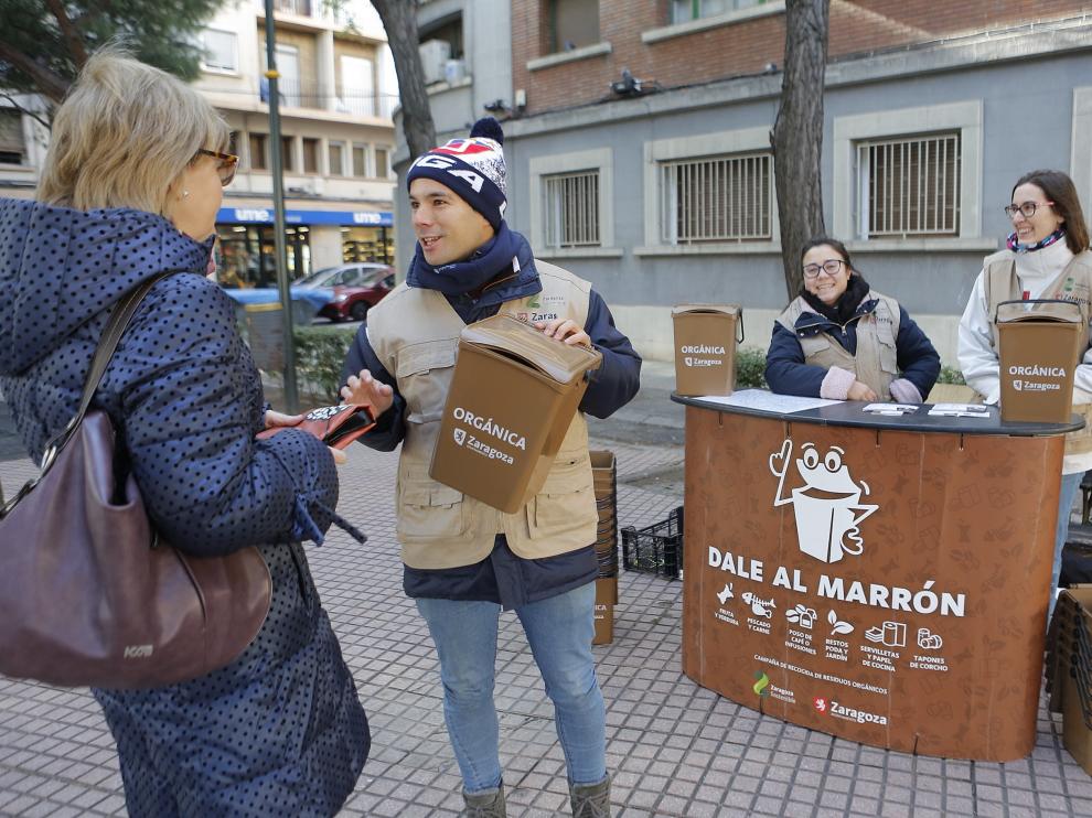 Un voluntario informa sobre el sistema de recogida en la calle de Tomás Bretón.